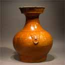 An Amber Glazed Pottery Jar with Mask Ring Handles 